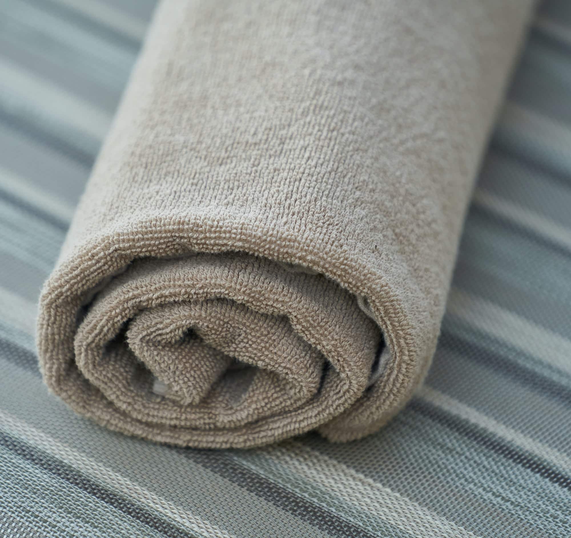 immagine di un asciugamano grigio perfettamente arrotolato
